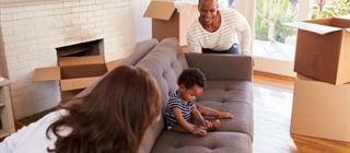 Couple moves a sofa into their new house.