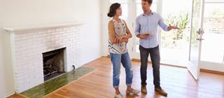 Male Realtor Showing Female Client Around House